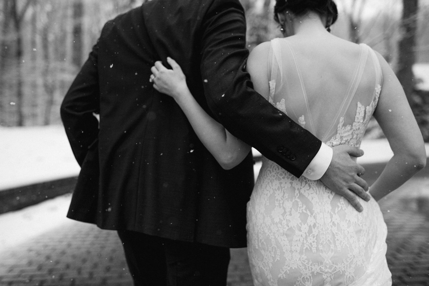 An intimate black and white portrait shows a couple embracing on their winter wedding day.