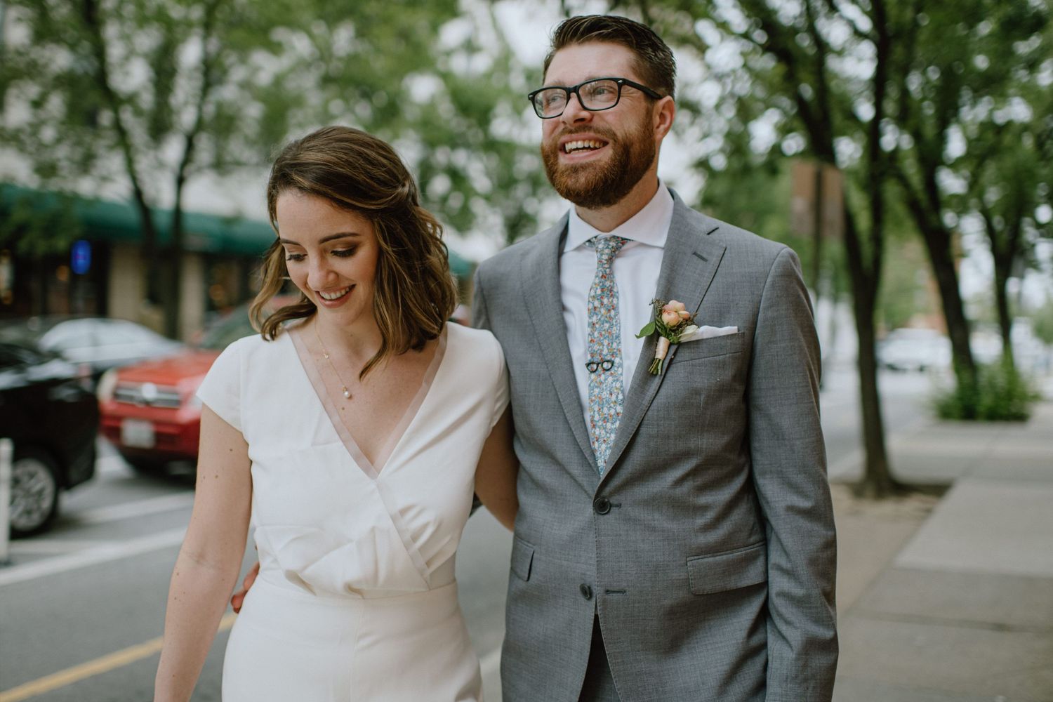 Urban wedding photo of couple walking together on city street.