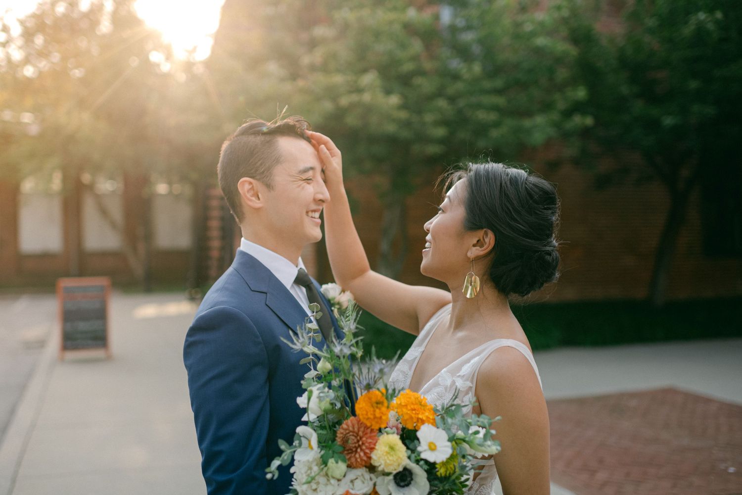 beautiful sun flare lights bride and groom as they smile on their wedding day