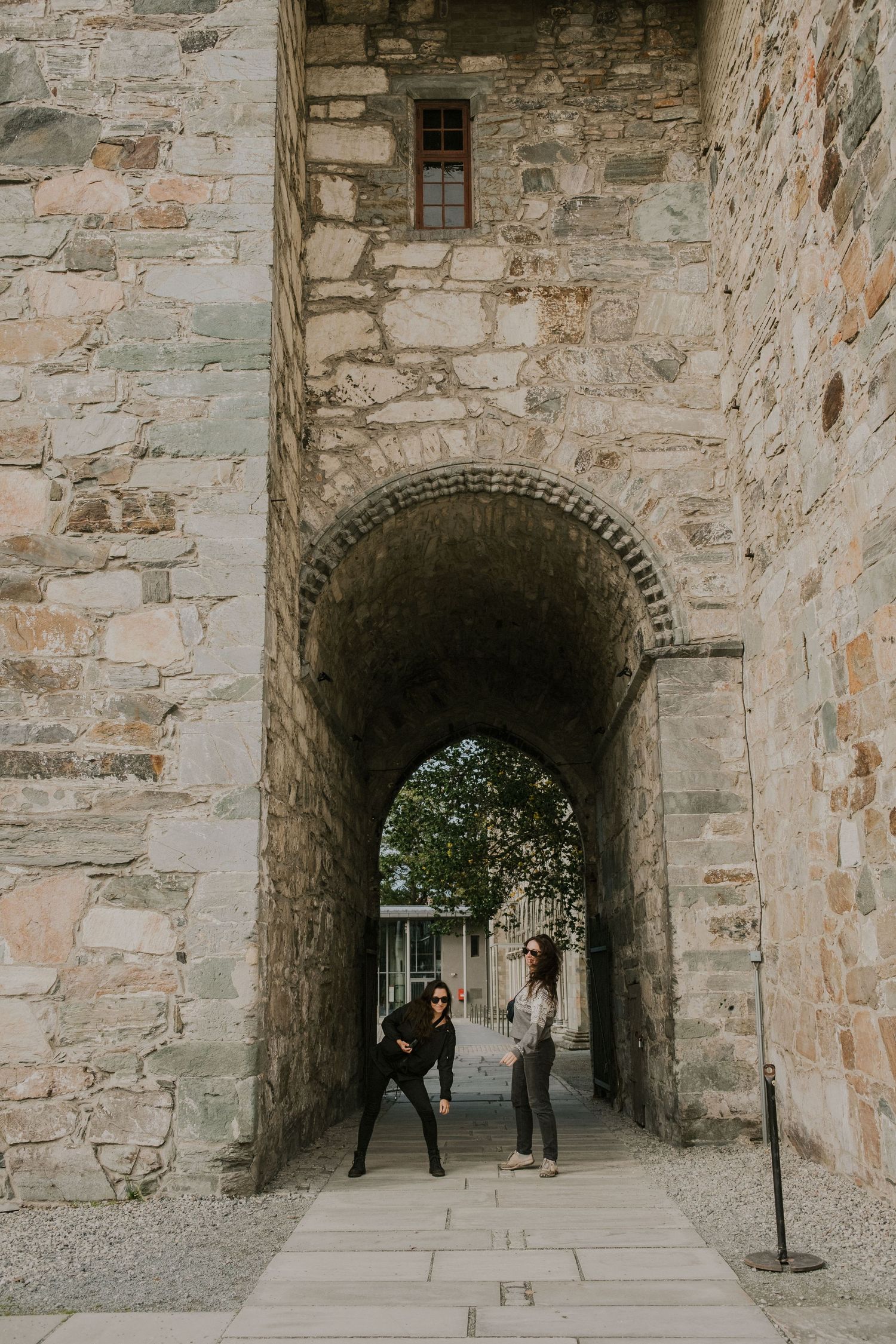 Stone archway passage in ancient castle wall with path leading through.