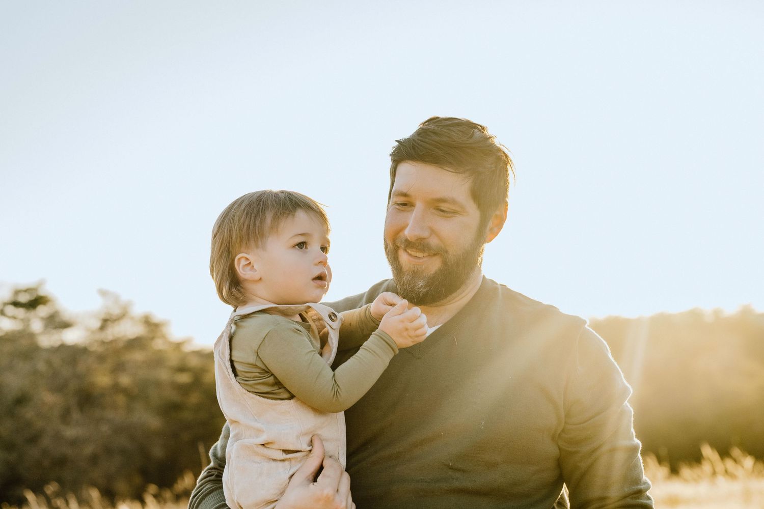 A heartwarming moment between parent and child against a glowing sunset backdrop.