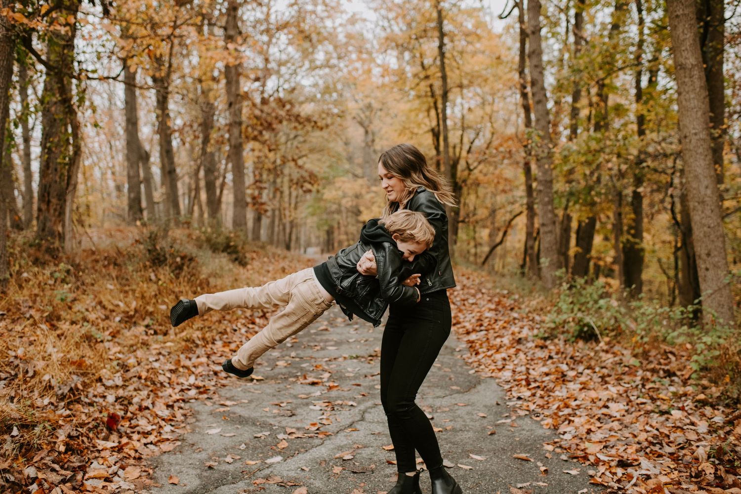 Playing together on an autumn trail surrounded by orange and brown foliage.