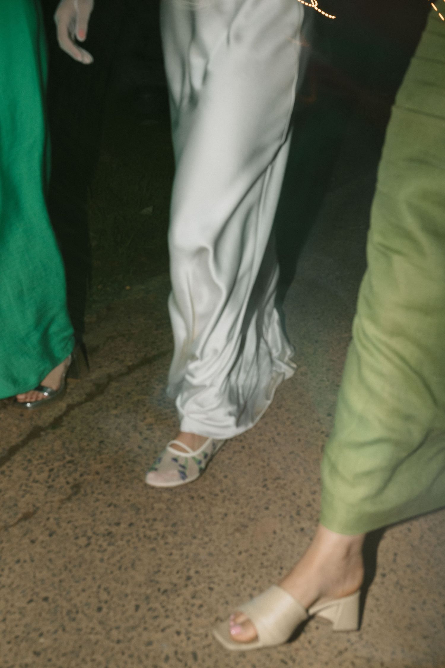 Wedding guests' feet and formal attire visible on a dance floor.