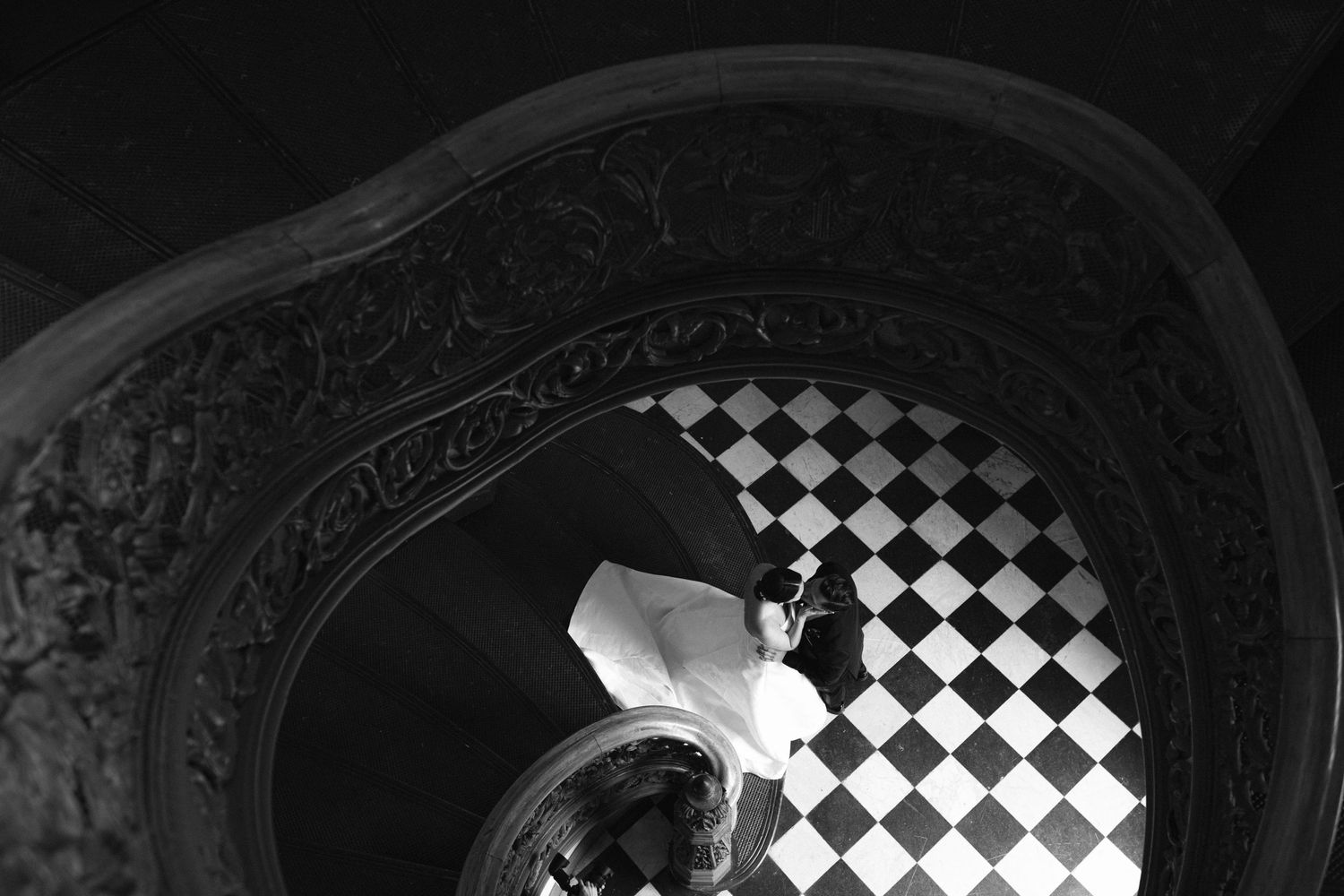Decorative black and white checkered pattern visible through an ornate window frame.