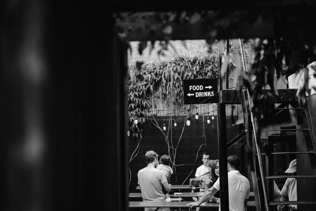 Black and white photo of a dimly lit restaurant interior with string lights.