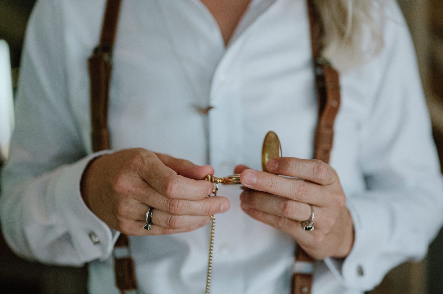 bride looking at pocket watch close up of rings wedding photography