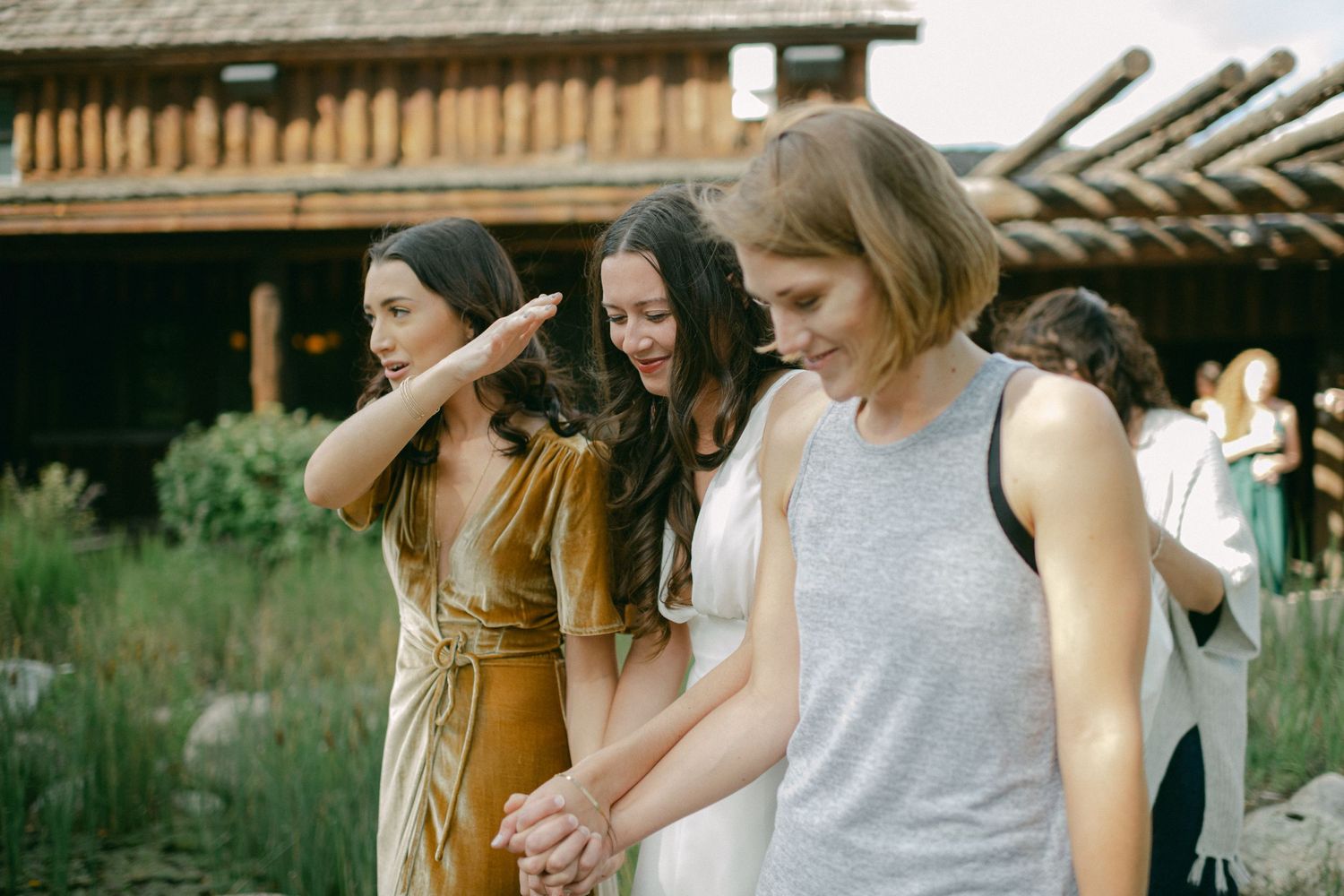 Wedding guests dancing together outside rustic barn venue.