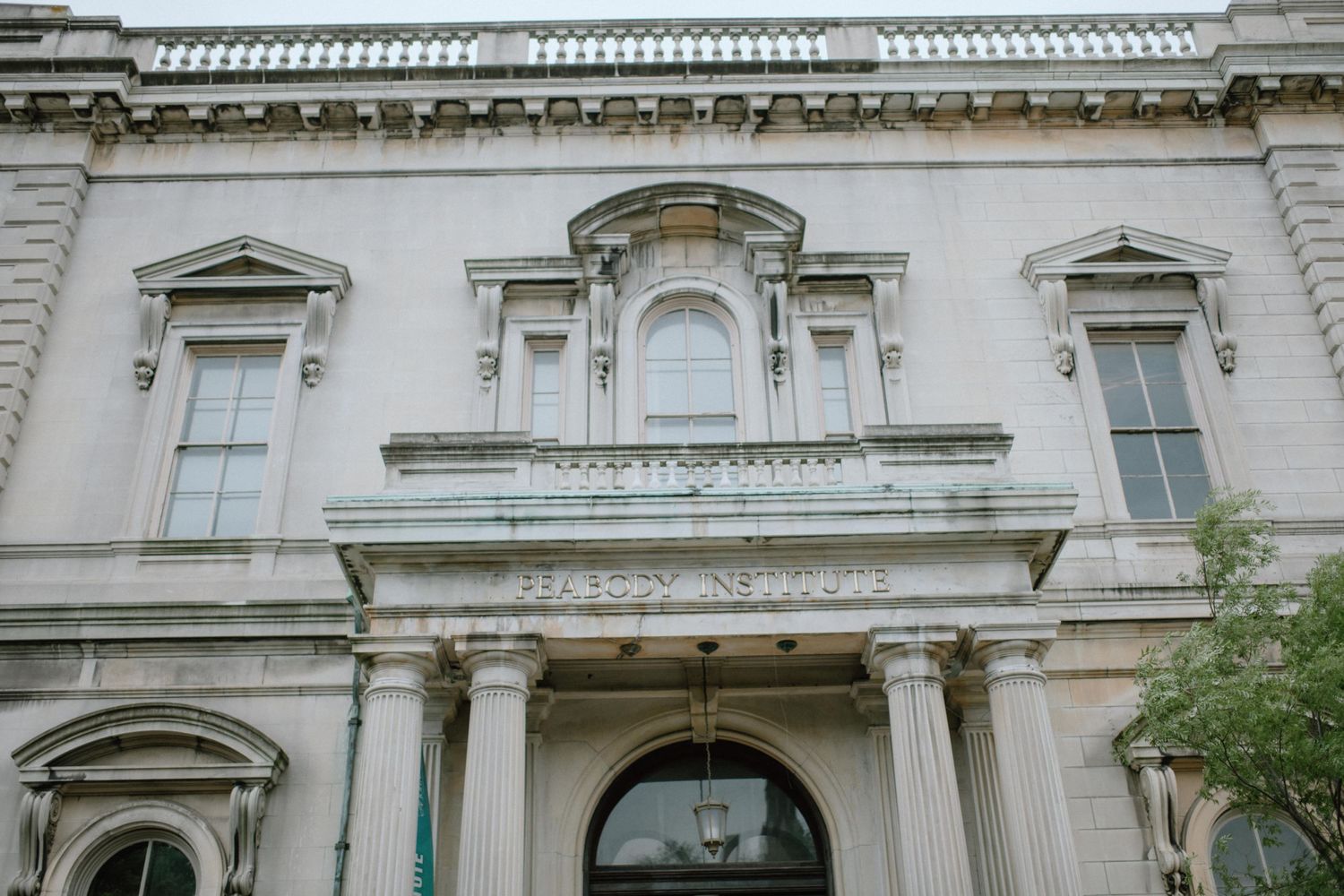 Elegant white stone building facade with classical architectural details and columns.