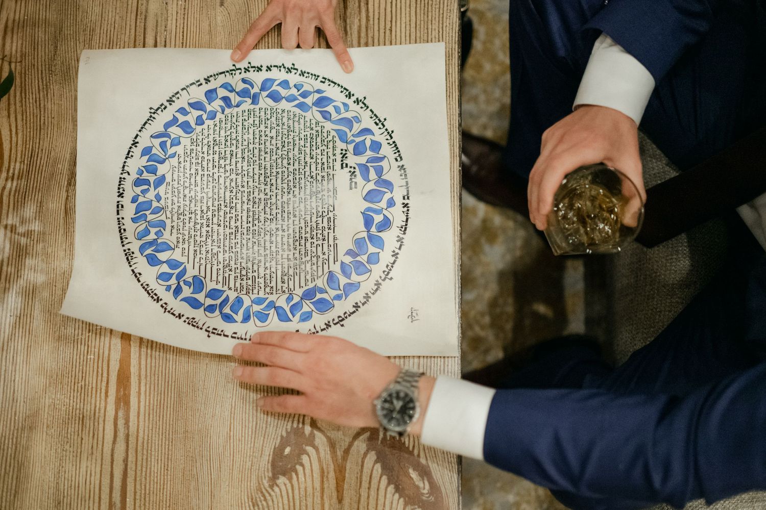 Hands hold a decorative plate with blue patterns while examining its details.