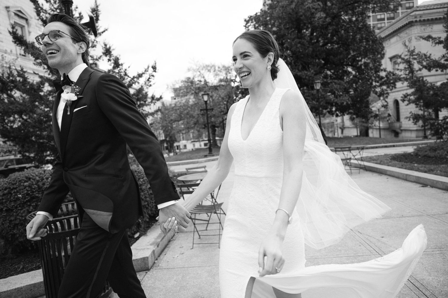 Wedding party members walking and posing outdoors with flowing dresses.