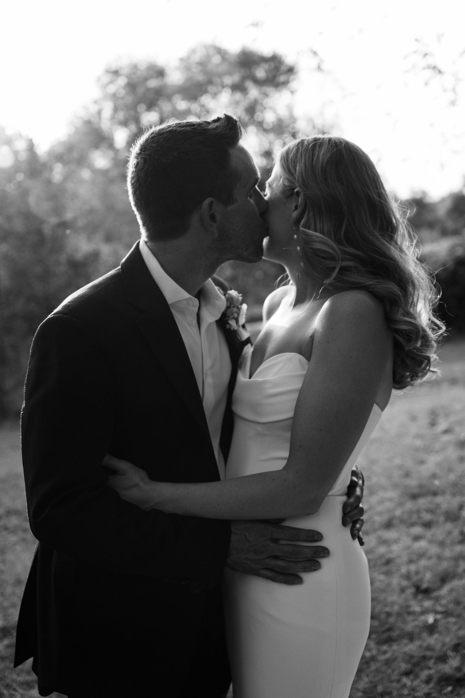 Romantic black and white wedding portrait captured in natural outdoor setting.
