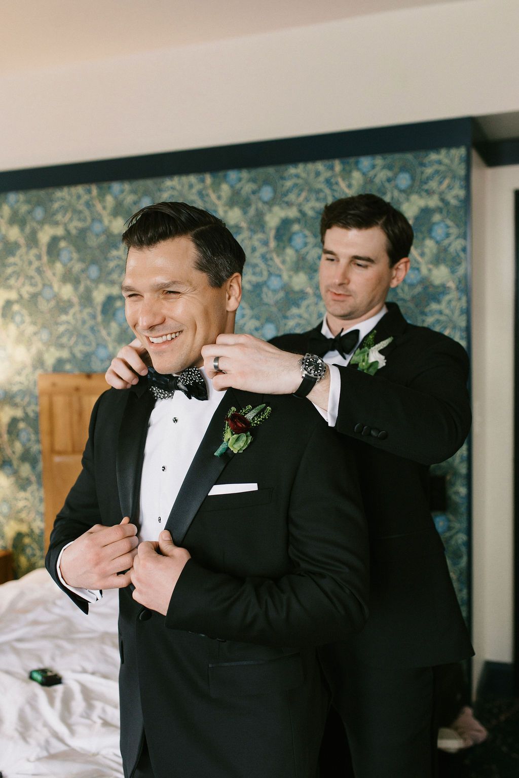 Groomsmen in tuxedos adjusting their formal attire before the ceremony.