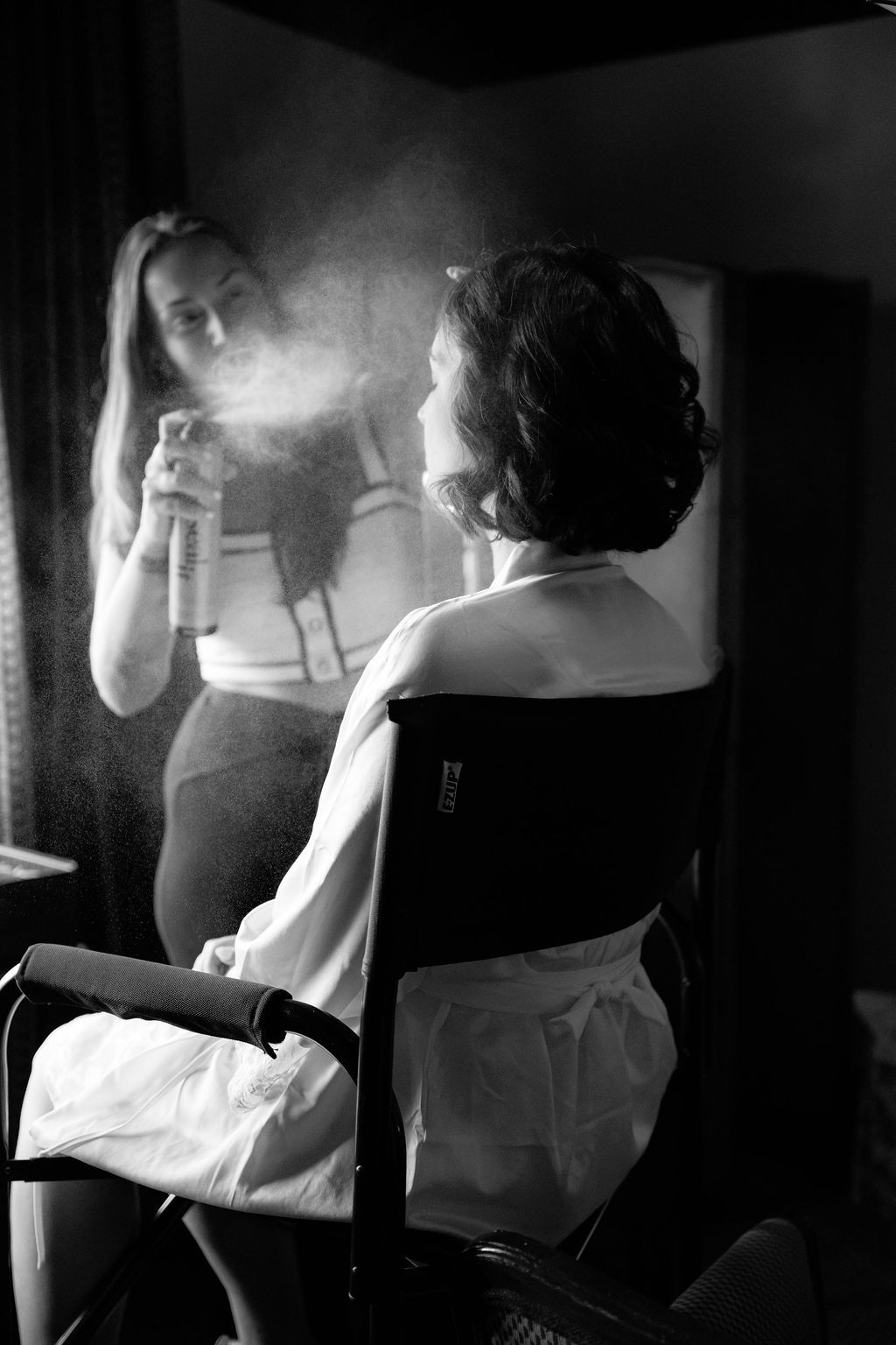 Black and white photographs show a woman getting dressed in vintage-style white undergarments and corsetry.