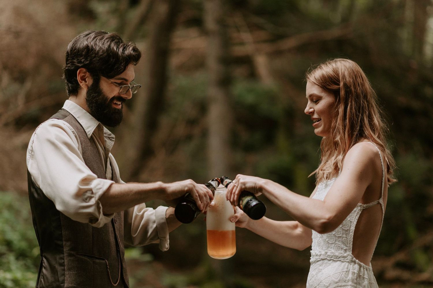 A couple shares drinks together during their forest wedding celebration.