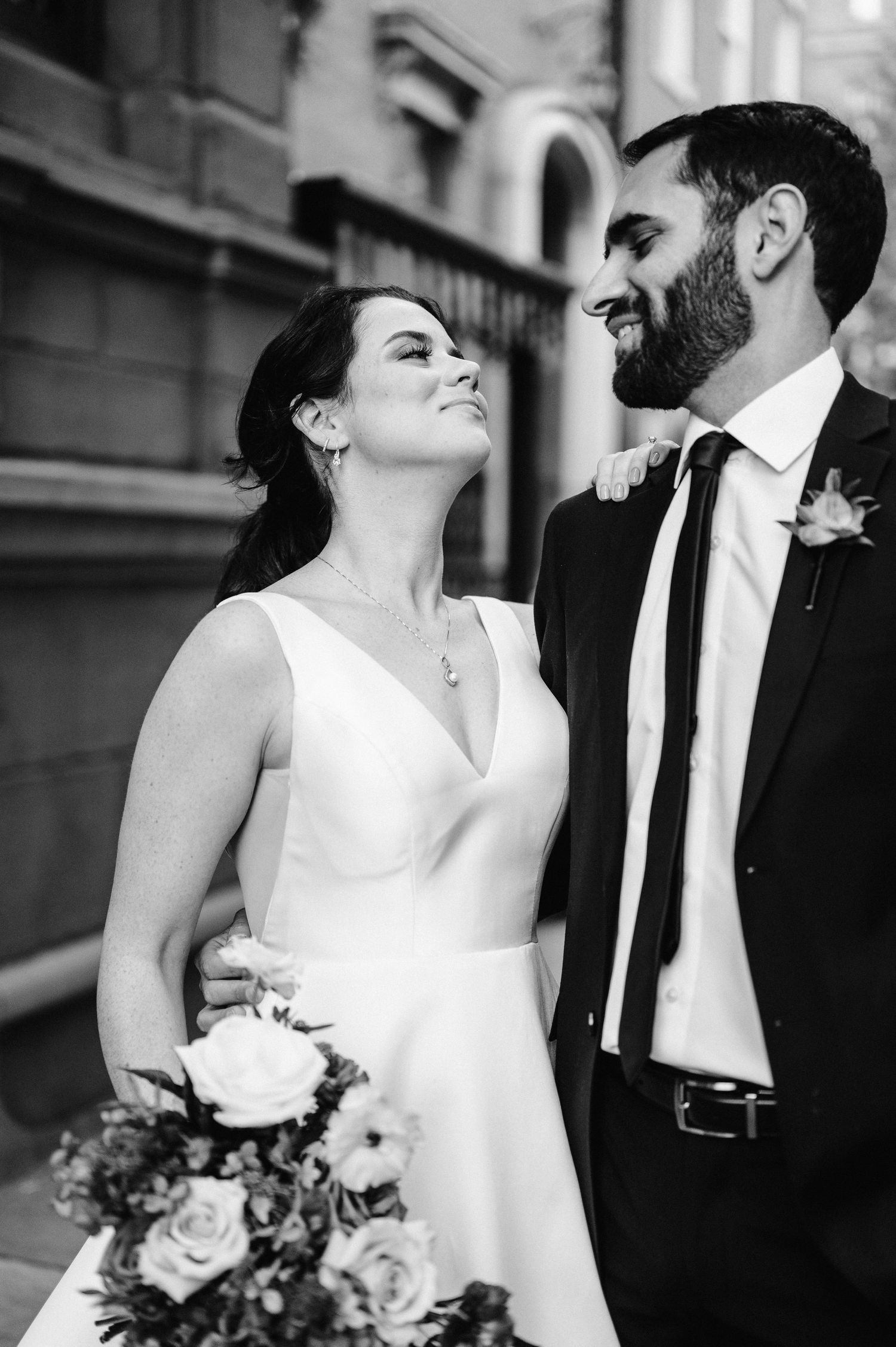 A joyful black and white portrait of newlyweds sharing a loving moment.