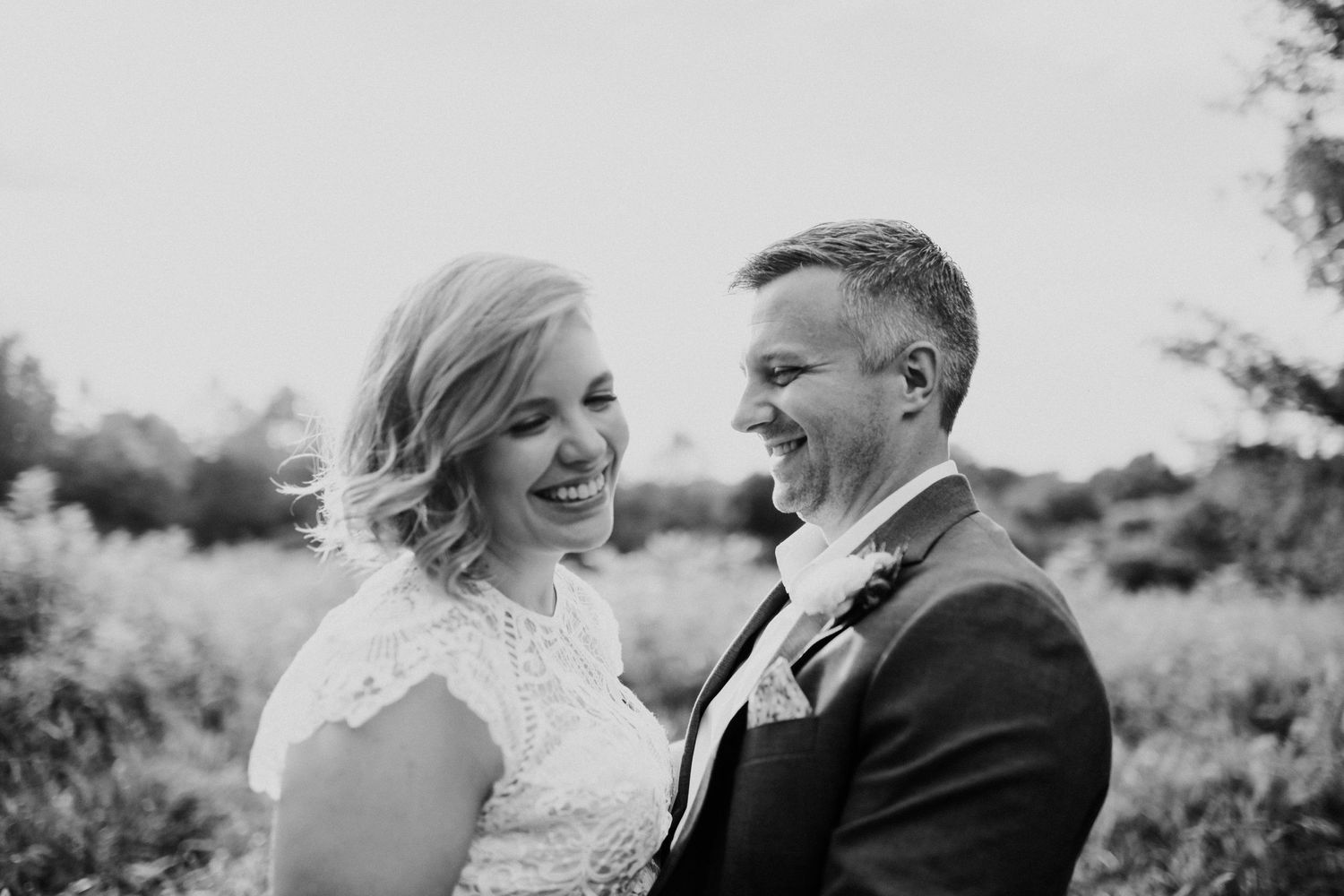 Joyful moment captured between couple in black and white outdoor portrait.