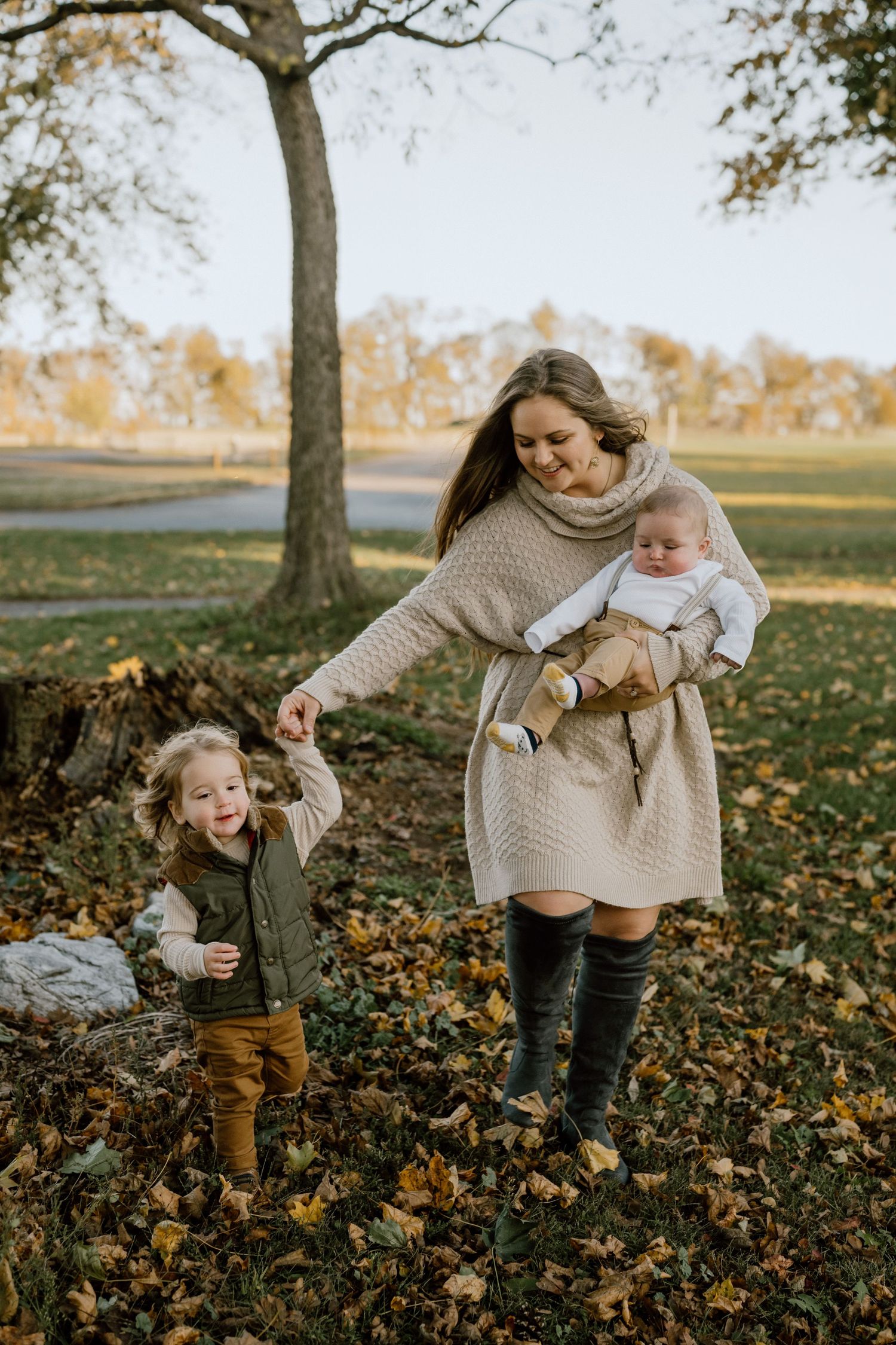 A playful autumn scene with people enjoying fallen leaves outdoors.
