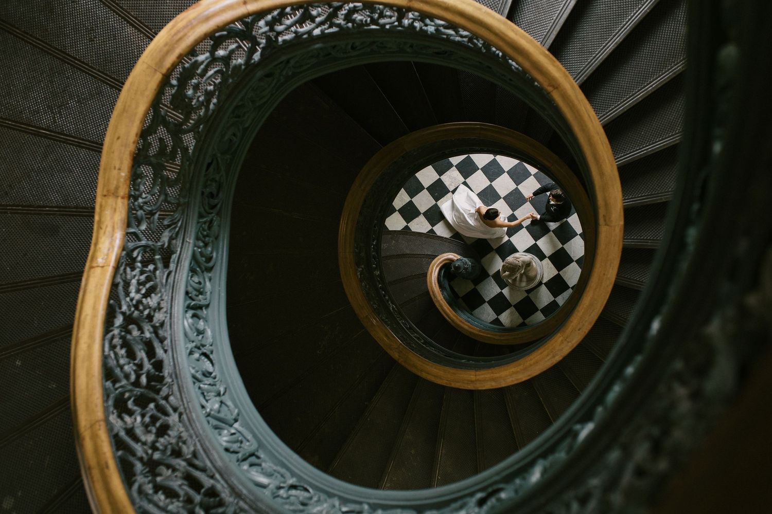 An ornate spiral staircase with wooden railing and black metalwork creates an elegant architectural detail.