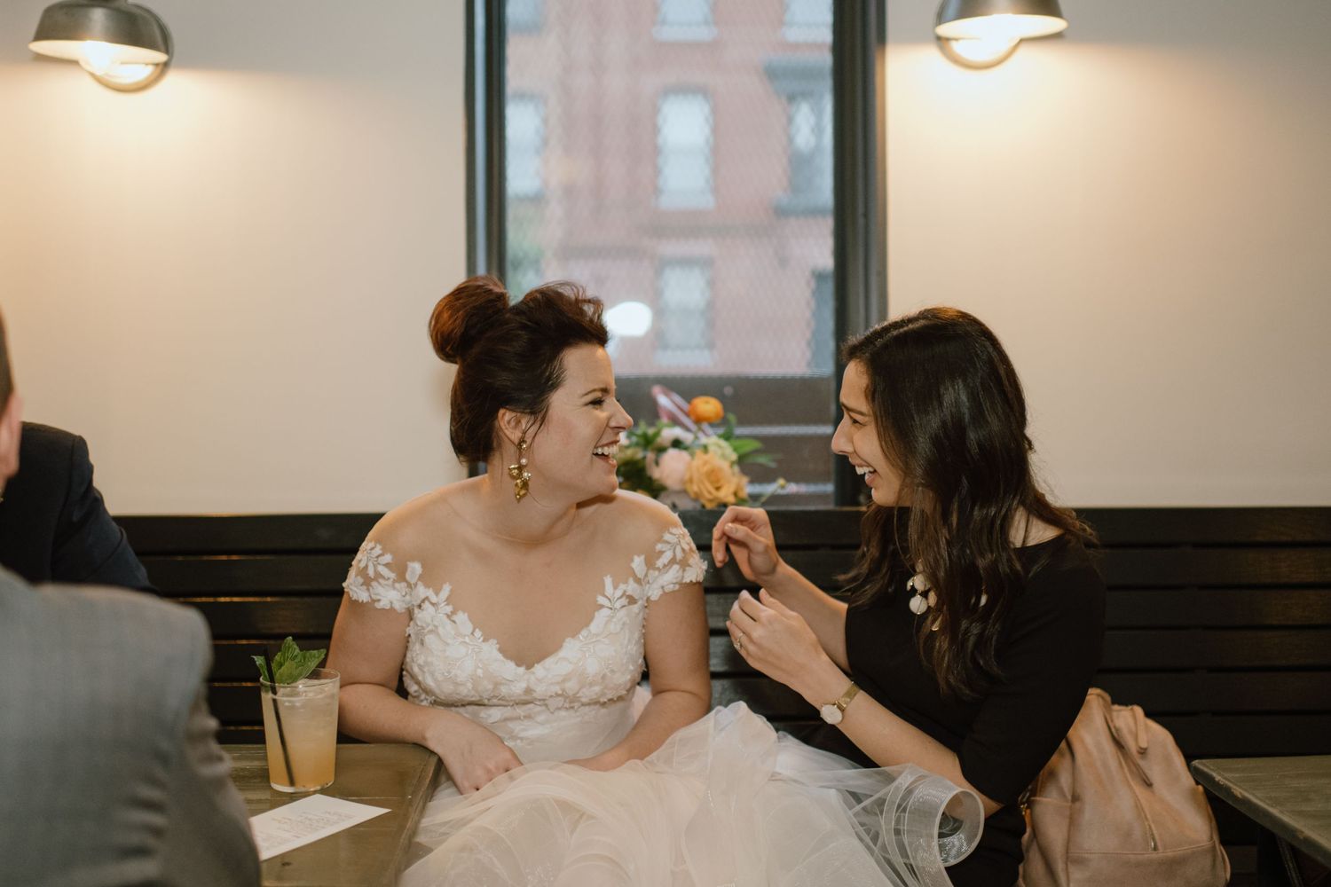 Two guests share a light-hearted moment during a wedding reception.
