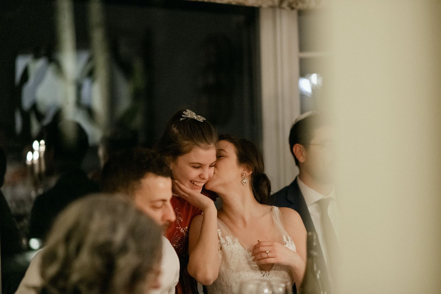 Emotional moment captured during wedding reception speeches in candlelit room.