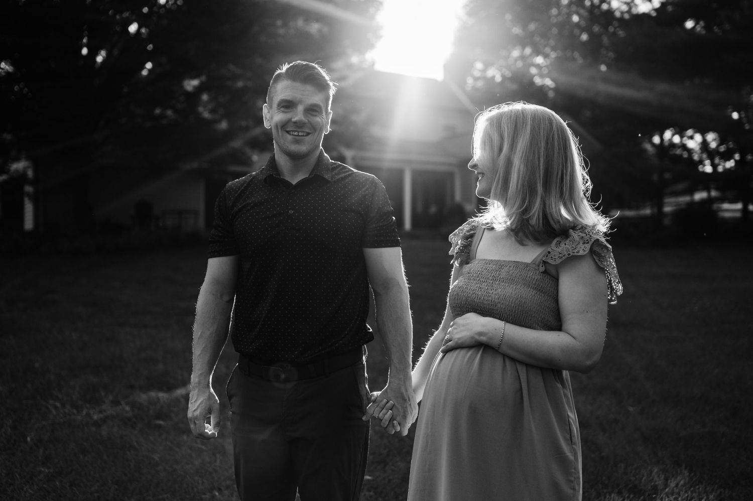 A black and white sunset portrait with dramatic backlighting in an outdoor setting.