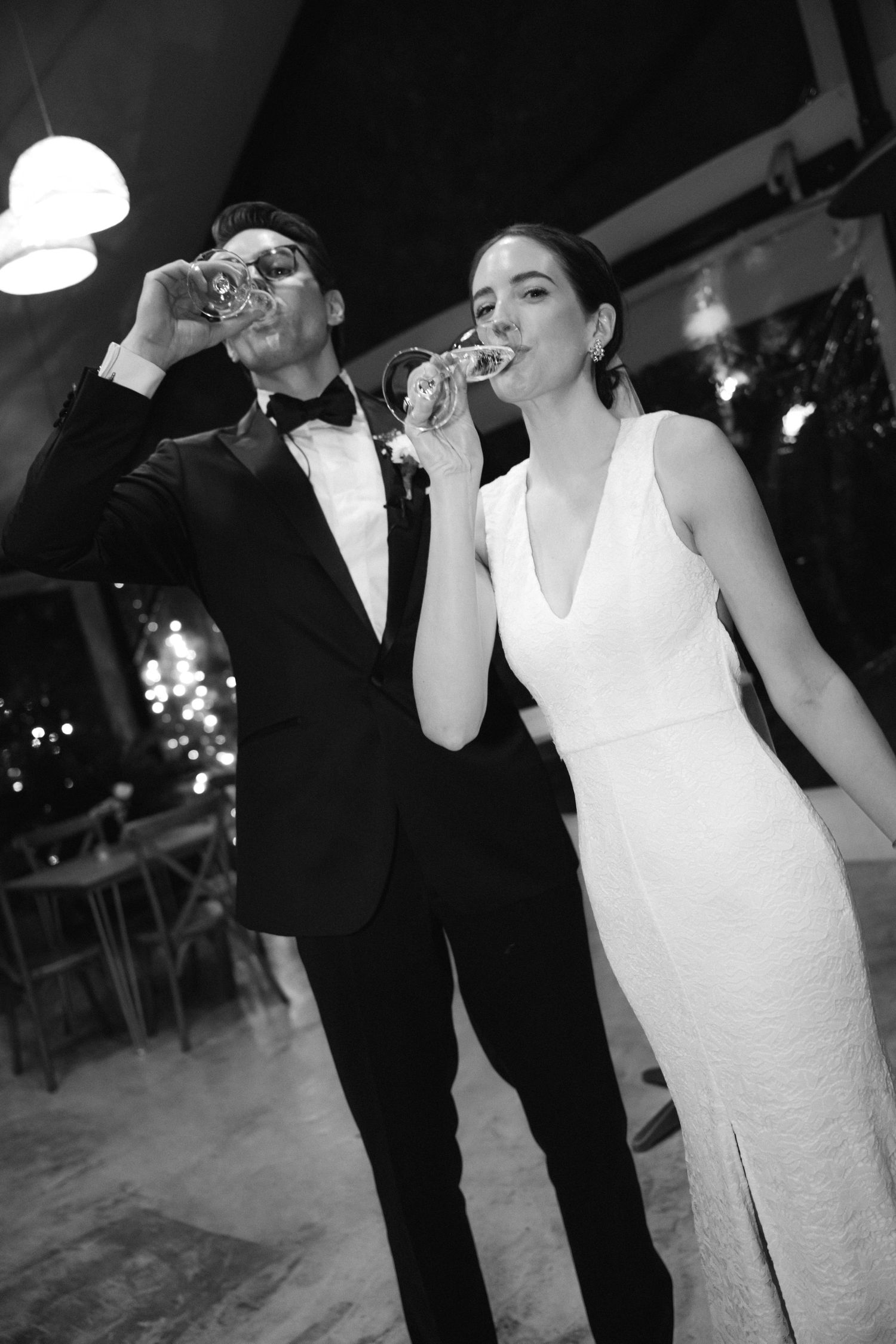 An elegantly dressed couple in formal attire sharing drinks at an evening celebration.