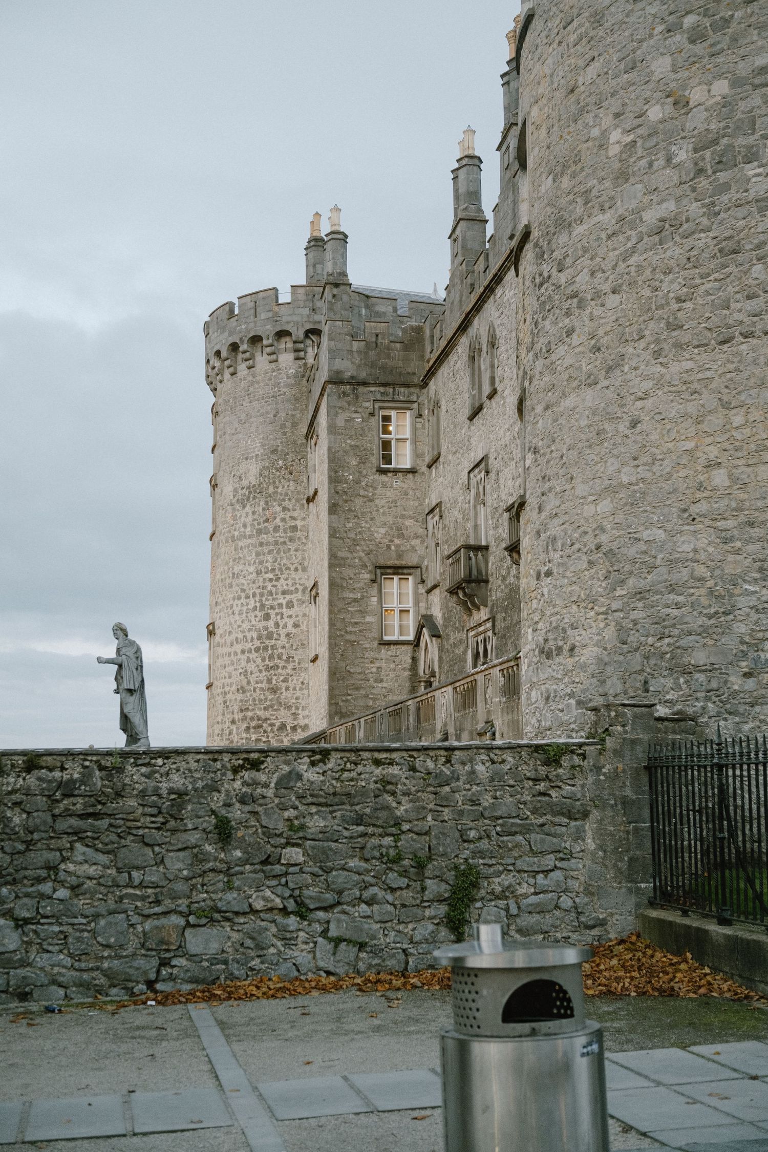 Medieval castle tower with stone walls and battlements against an overcast sky.