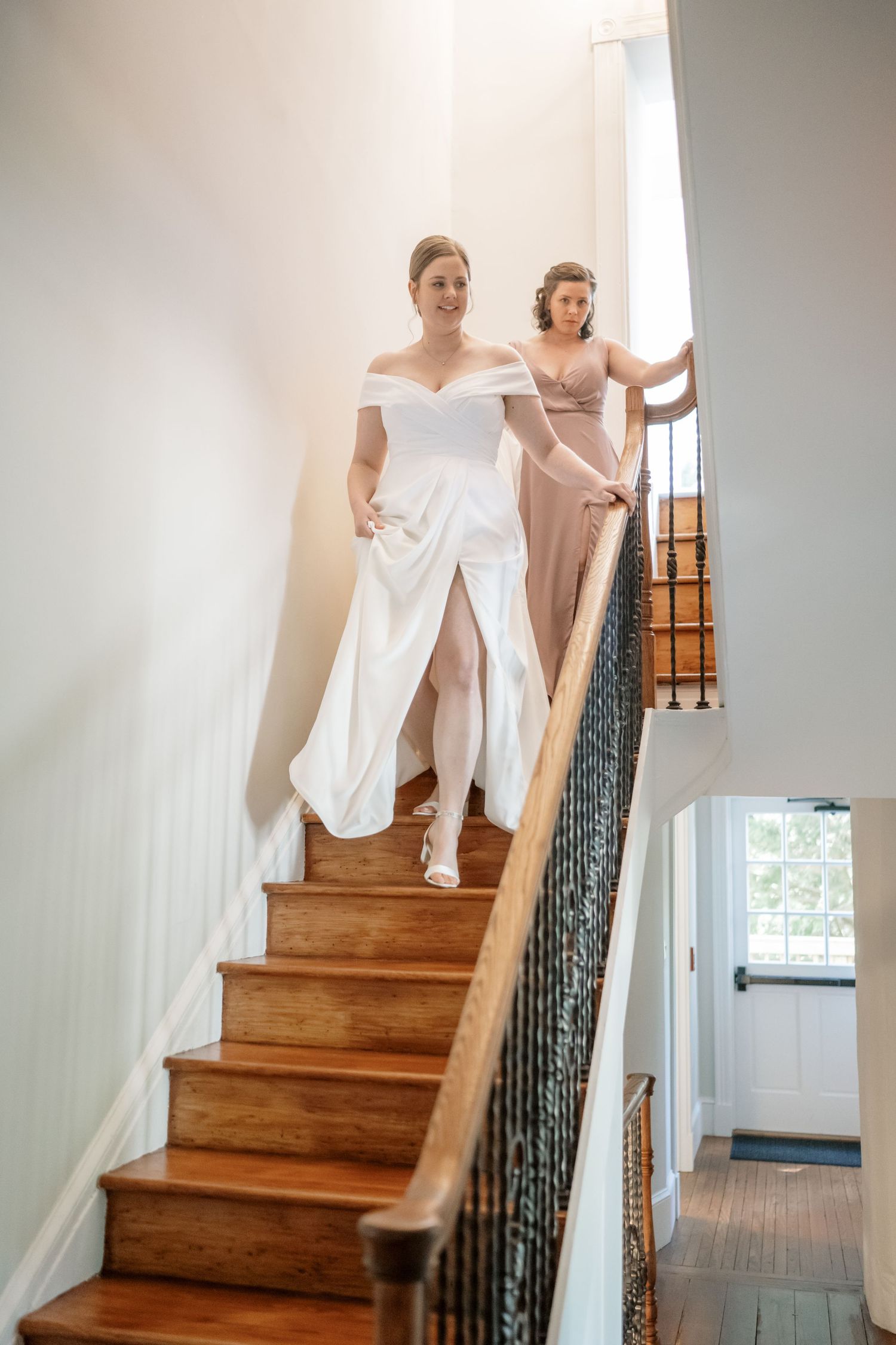 bride walks down stairs at the inn at mt. ida historic wedding view