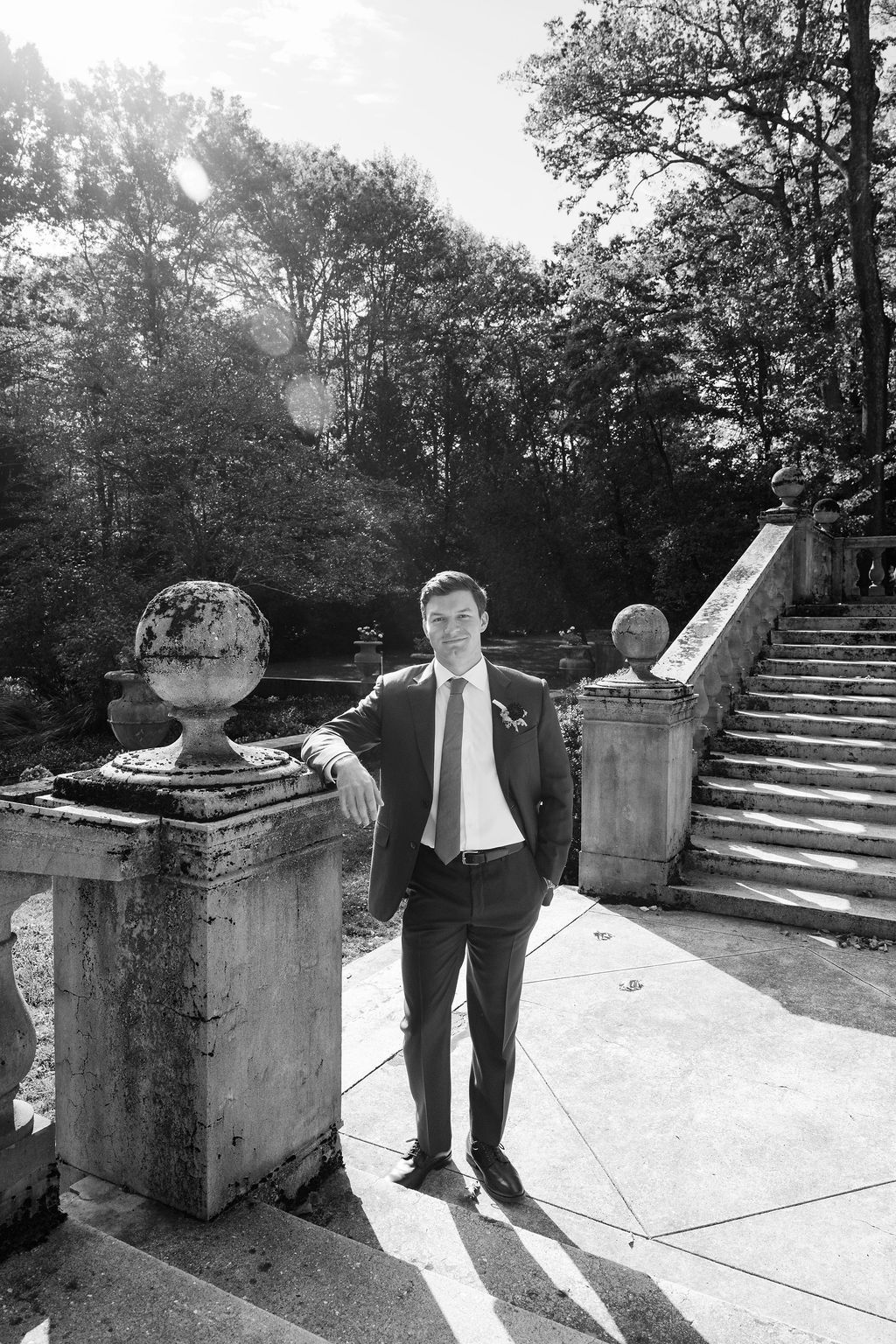 Black and white photo of someone exploring stone steps and architectural details outdoors.