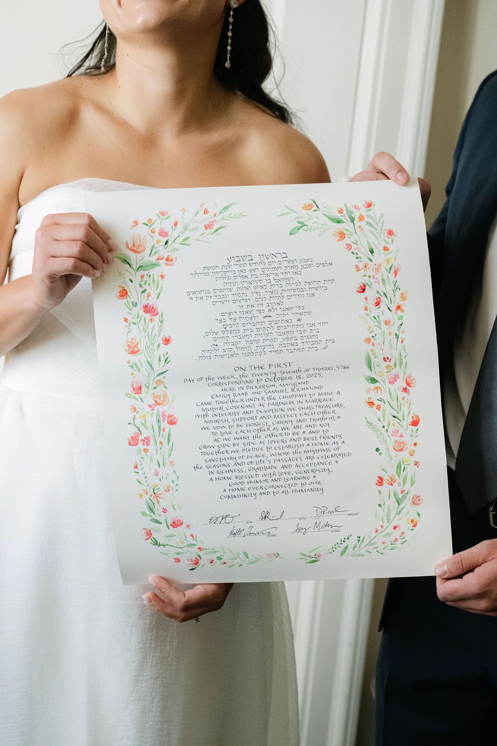 Wedding document with floral border design being displayed.