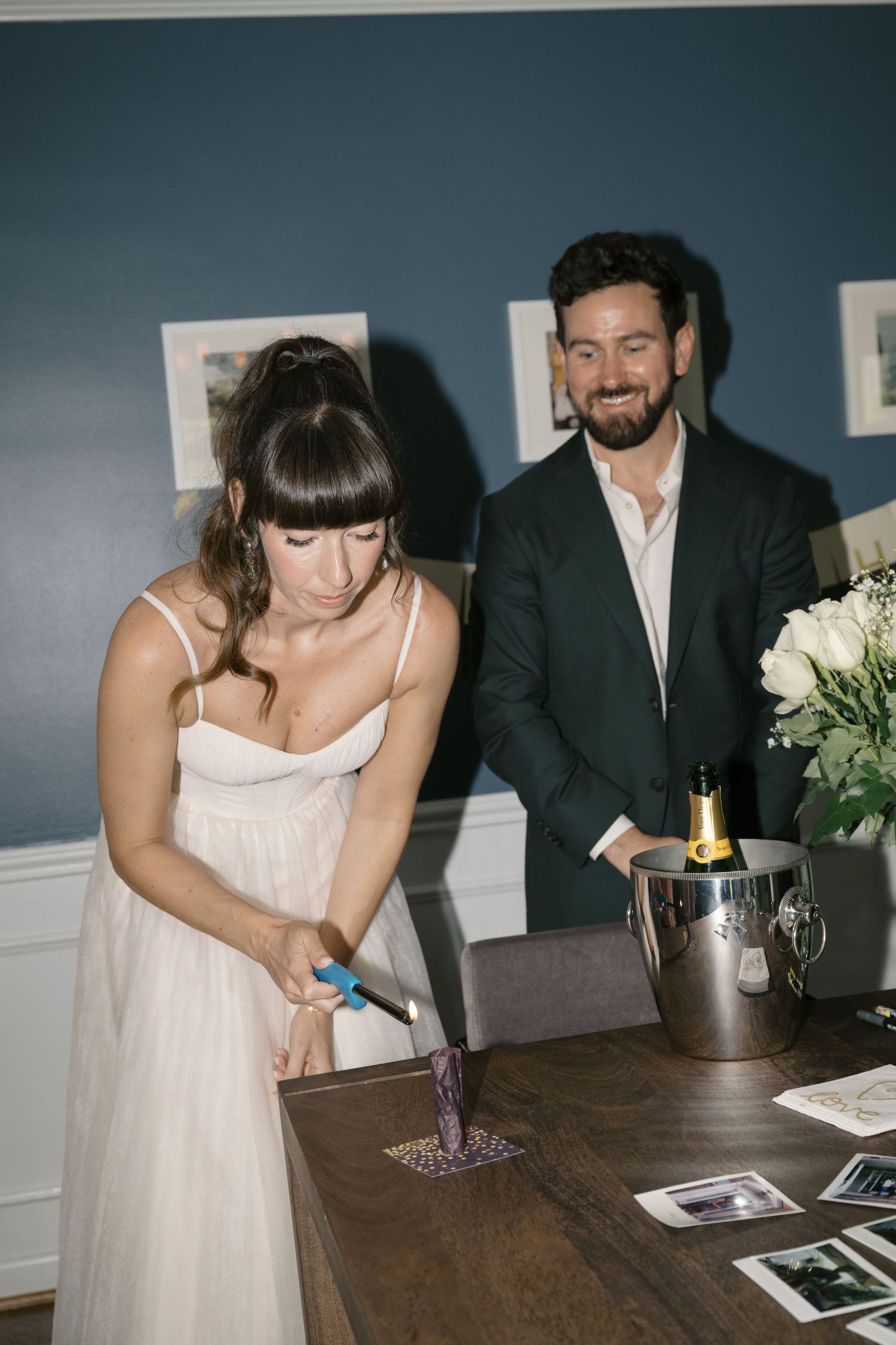People signing a guest book on dark wooden table at formal event with elegant black and white decor.