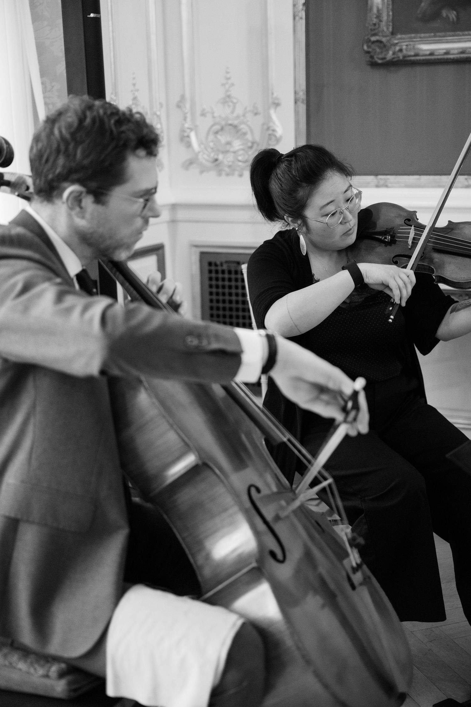Classical musicians performing with string instruments in a formal setting.