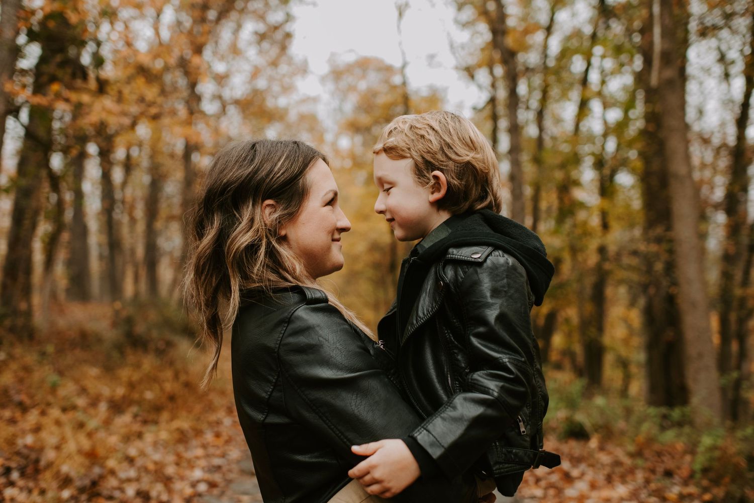 A tender moment shared between parent and child among fall foliage.