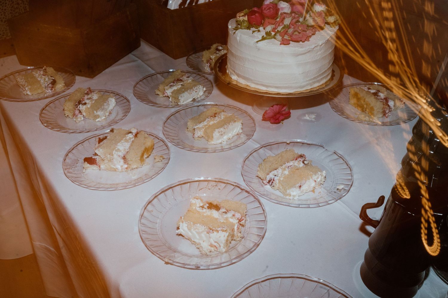 Wedding cake slices plated on decorative china dishes at reception.