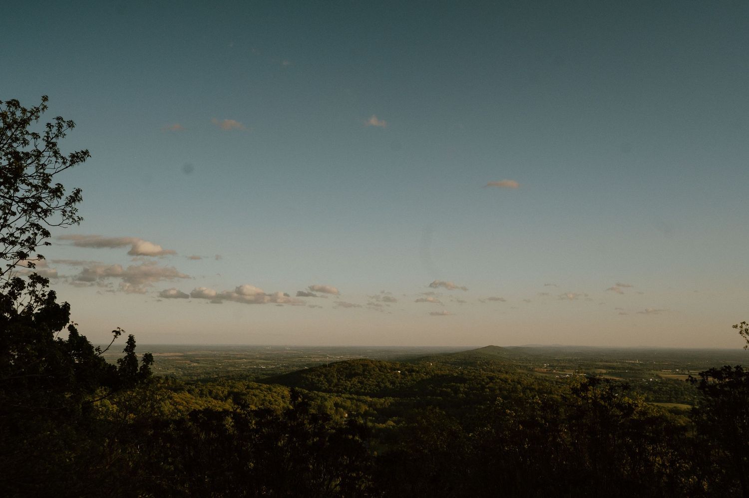 Scenic sunset view over rolling hills and distant landscapes.