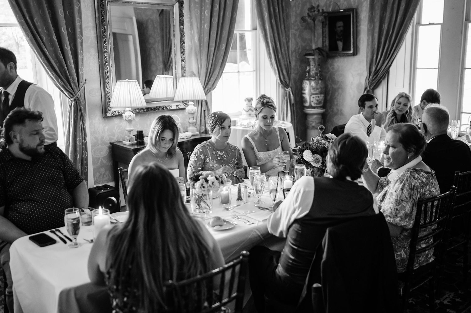 Black and white photo of guests dining at an elegant table in a formal room.