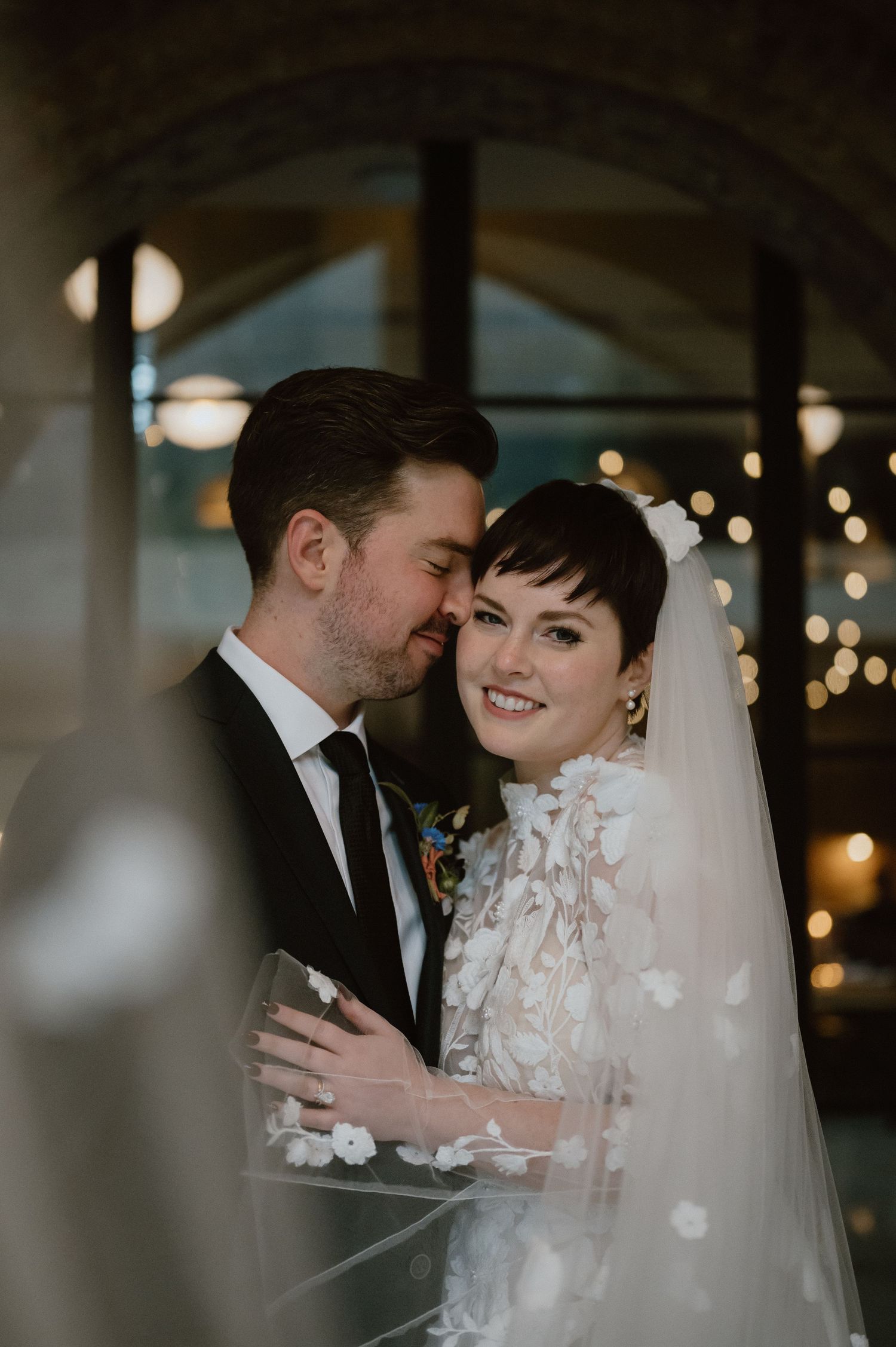 A romantic moment between newlyweds as they embrace under soft lighting.