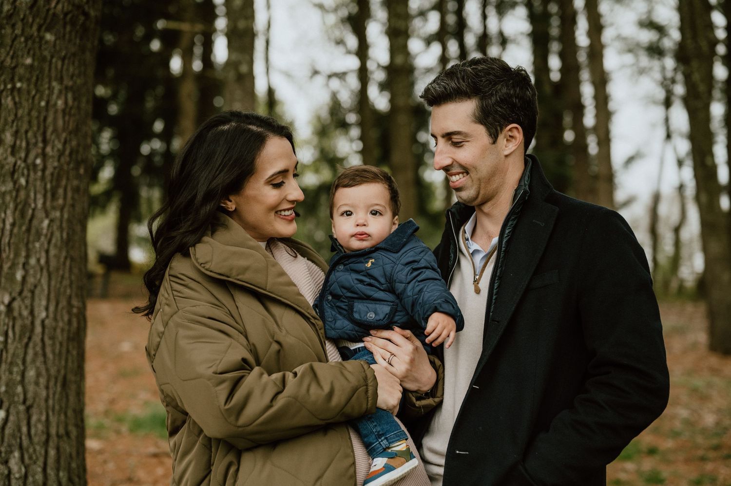 Outdoor family portrait in wooded setting with fall colors.