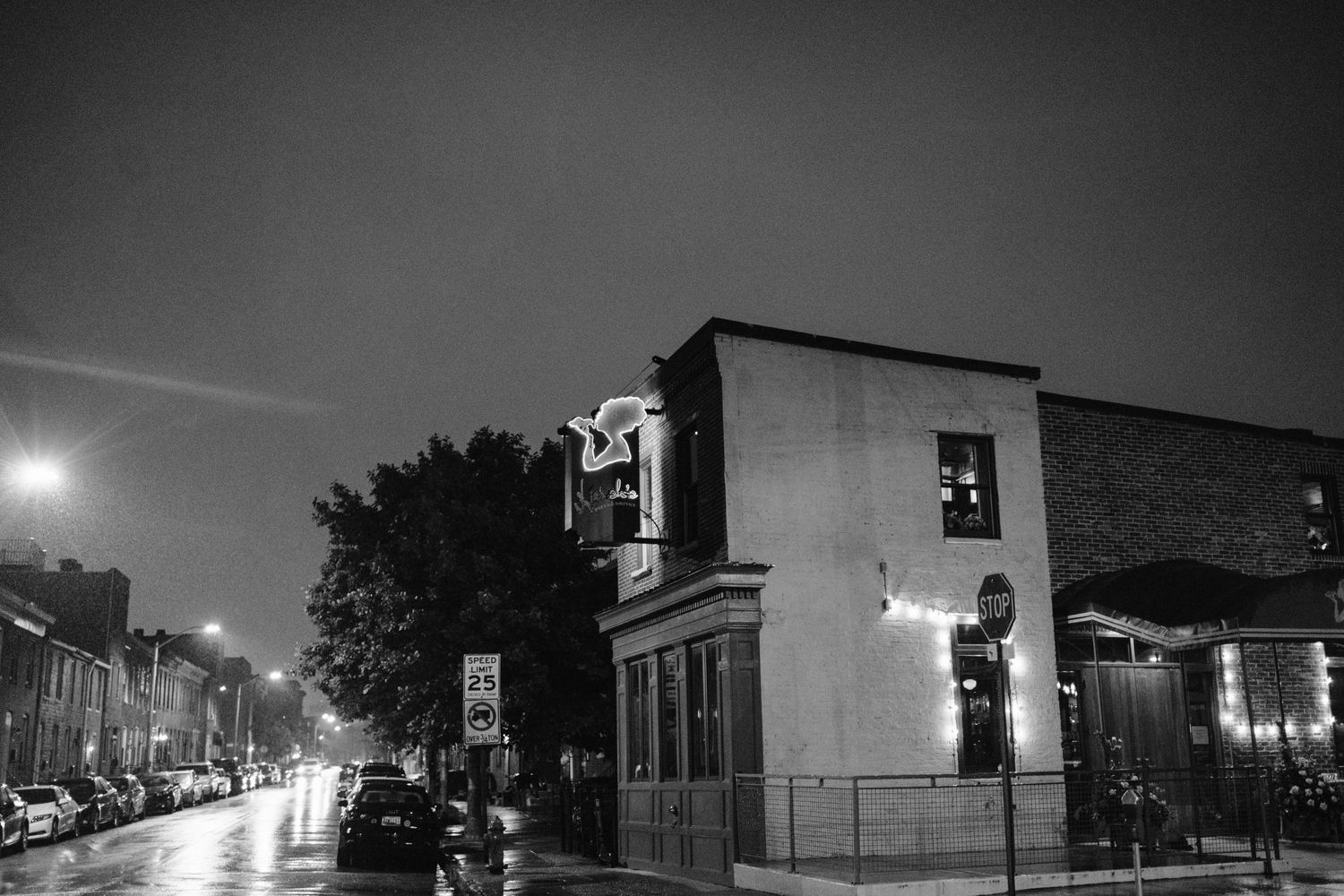 Black and white nighttime street scene of a building with ambient lighting.