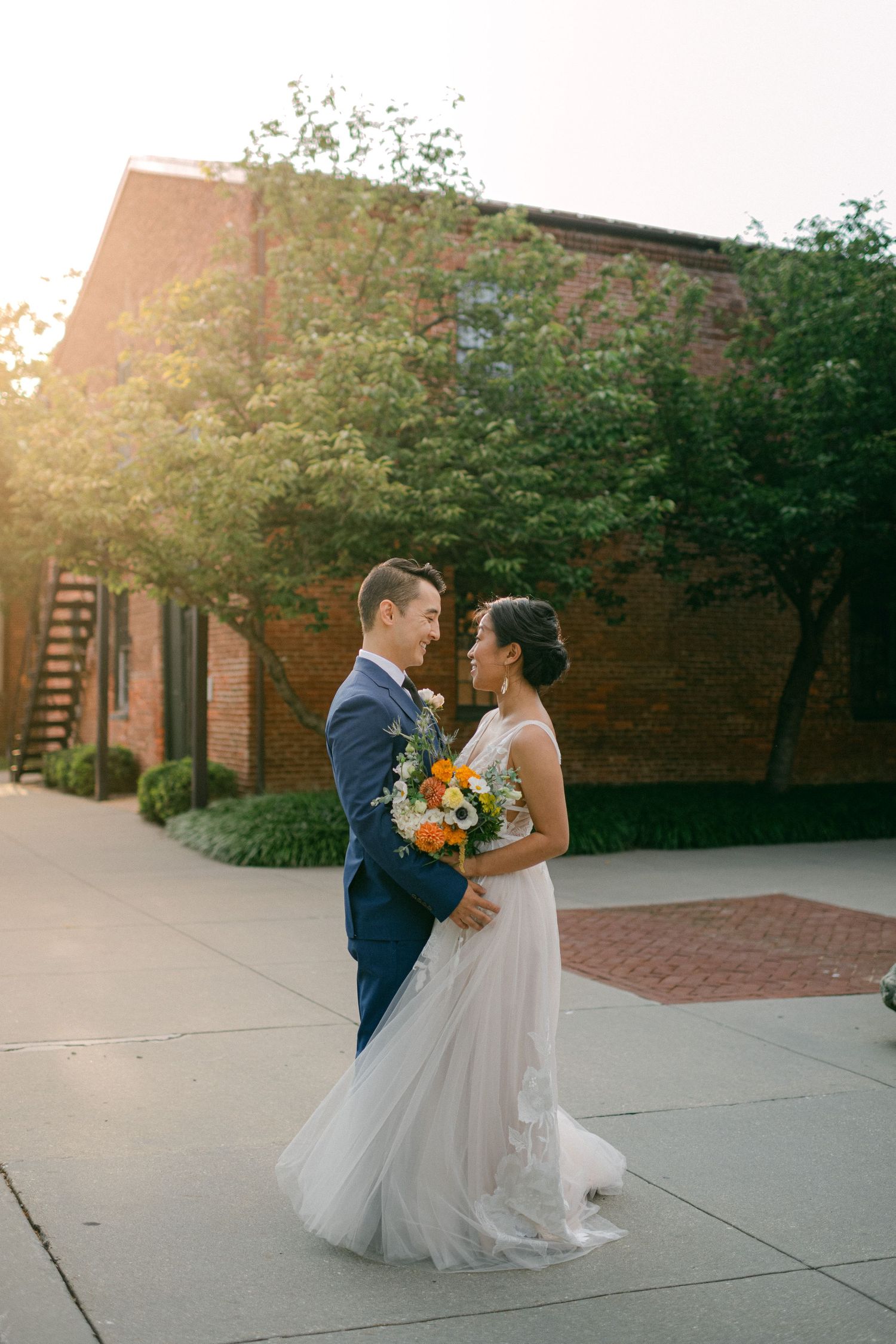 beautiful sun flare lights bride and groom as they smile on their wedding day