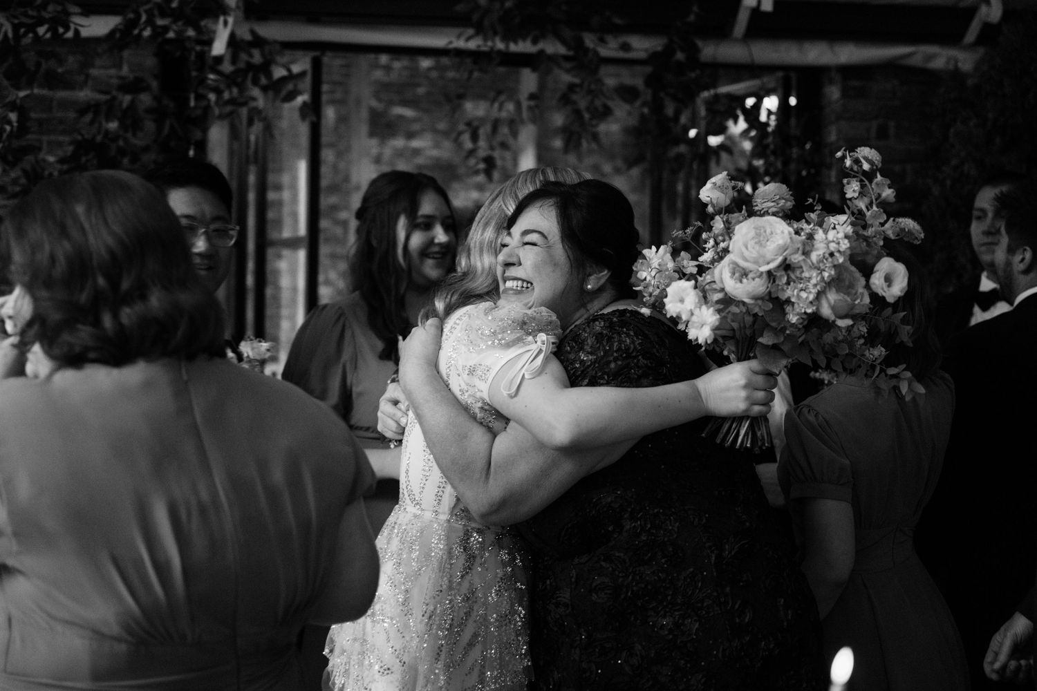 A joyful embrace between two people at a wedding celebration.