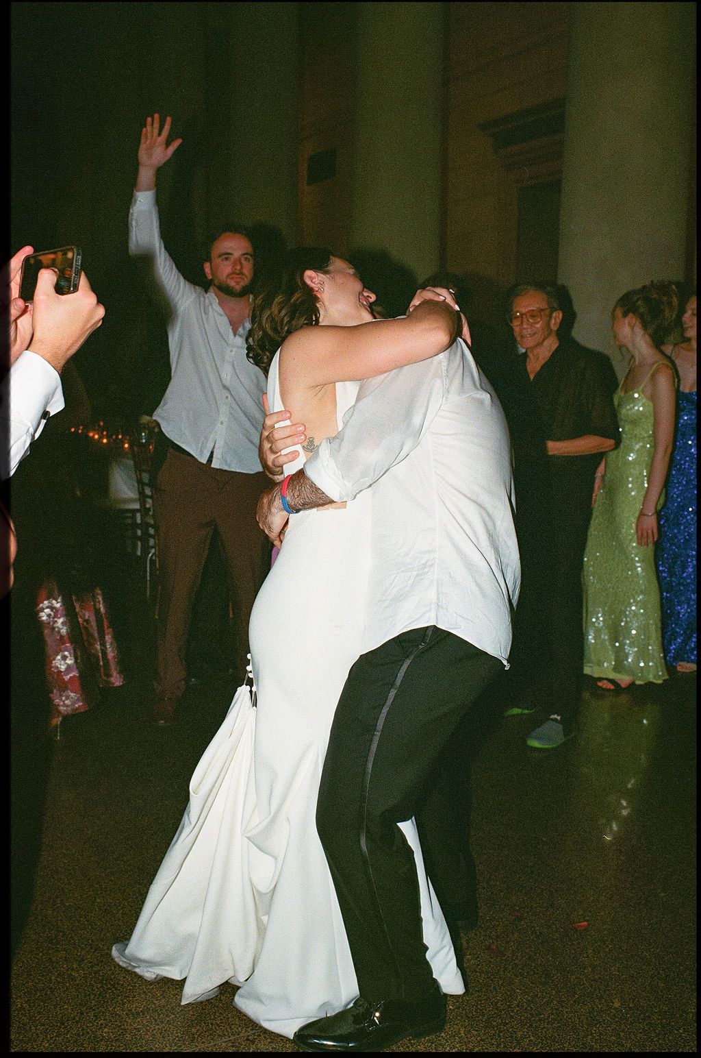 A couple performs a dramatic dance dip move on the dance floor at a formal event.