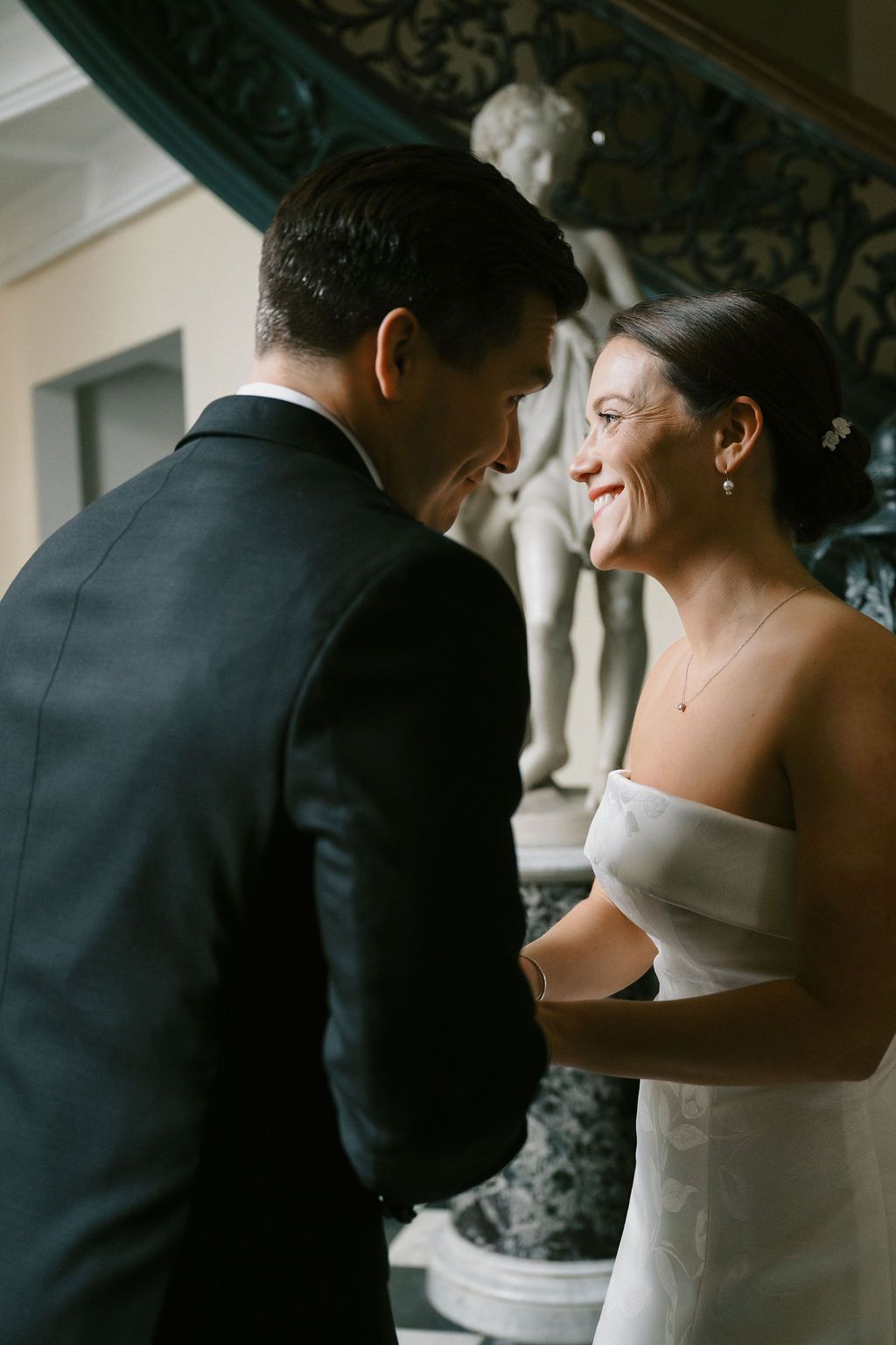 Intimate moment captured on elegant staircase during wedding.