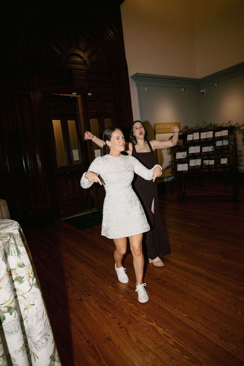 Person in white outfit dancing energetically on hardwood floor.