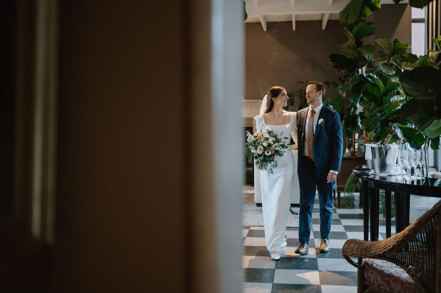Elegant wedding moment captured through a doorway in an interior setting.