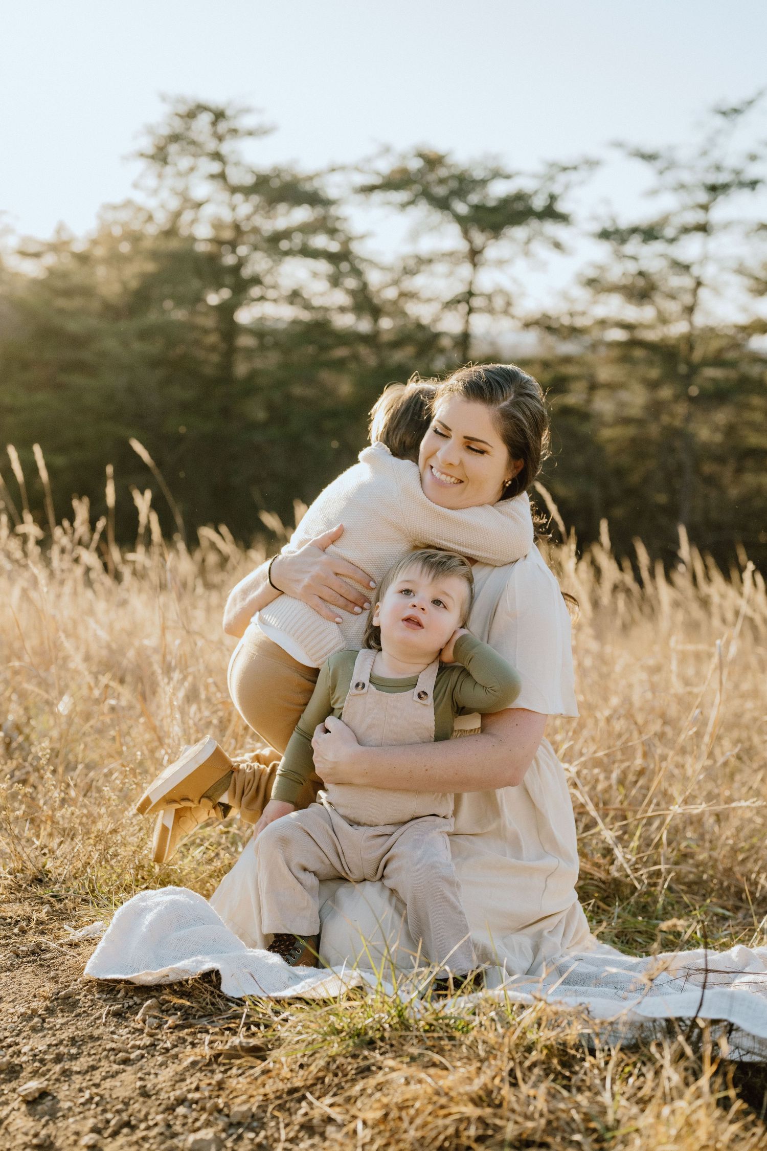 Heartwarming family moment captured in golden sunlight amidst tall grass.