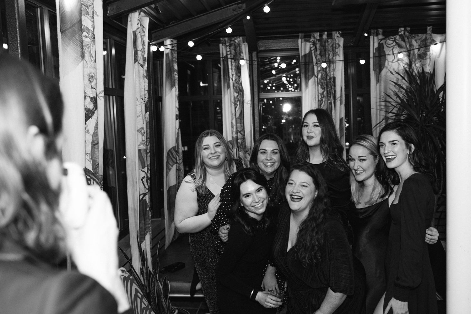 Group in black attire gathered at an indoor evening event.