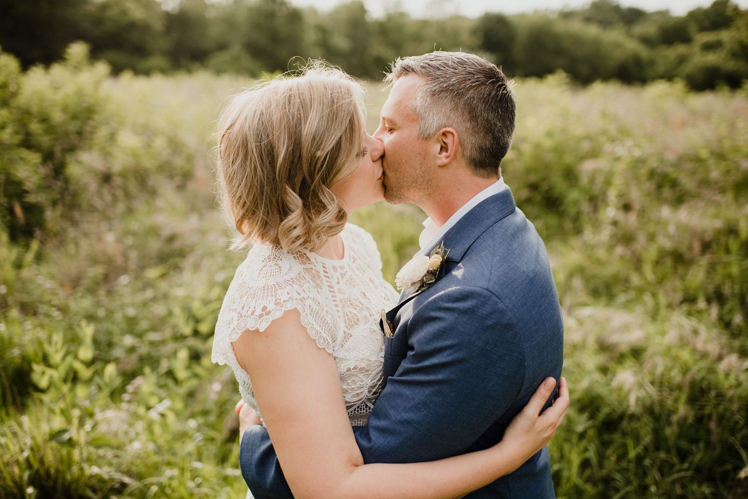 Intimate outdoor portrait of couple embracing in natural summer setting.