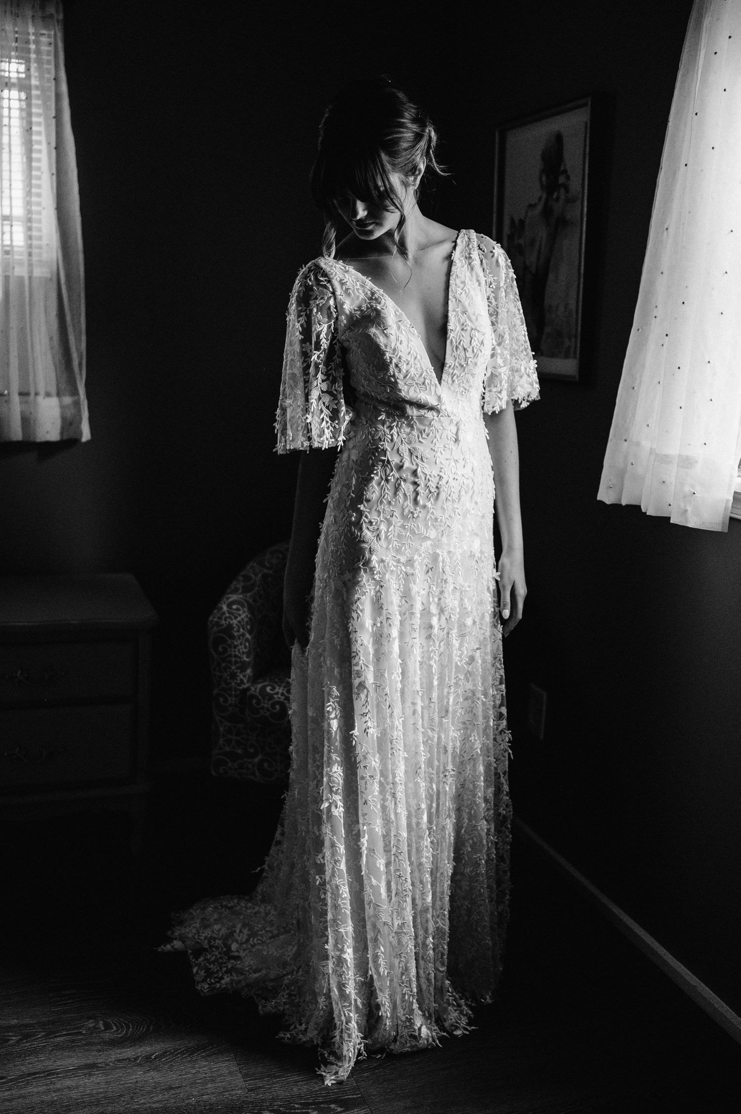 Dramatic black and white portrait of a bride wearing a vintage-inspired lace wedding gown.