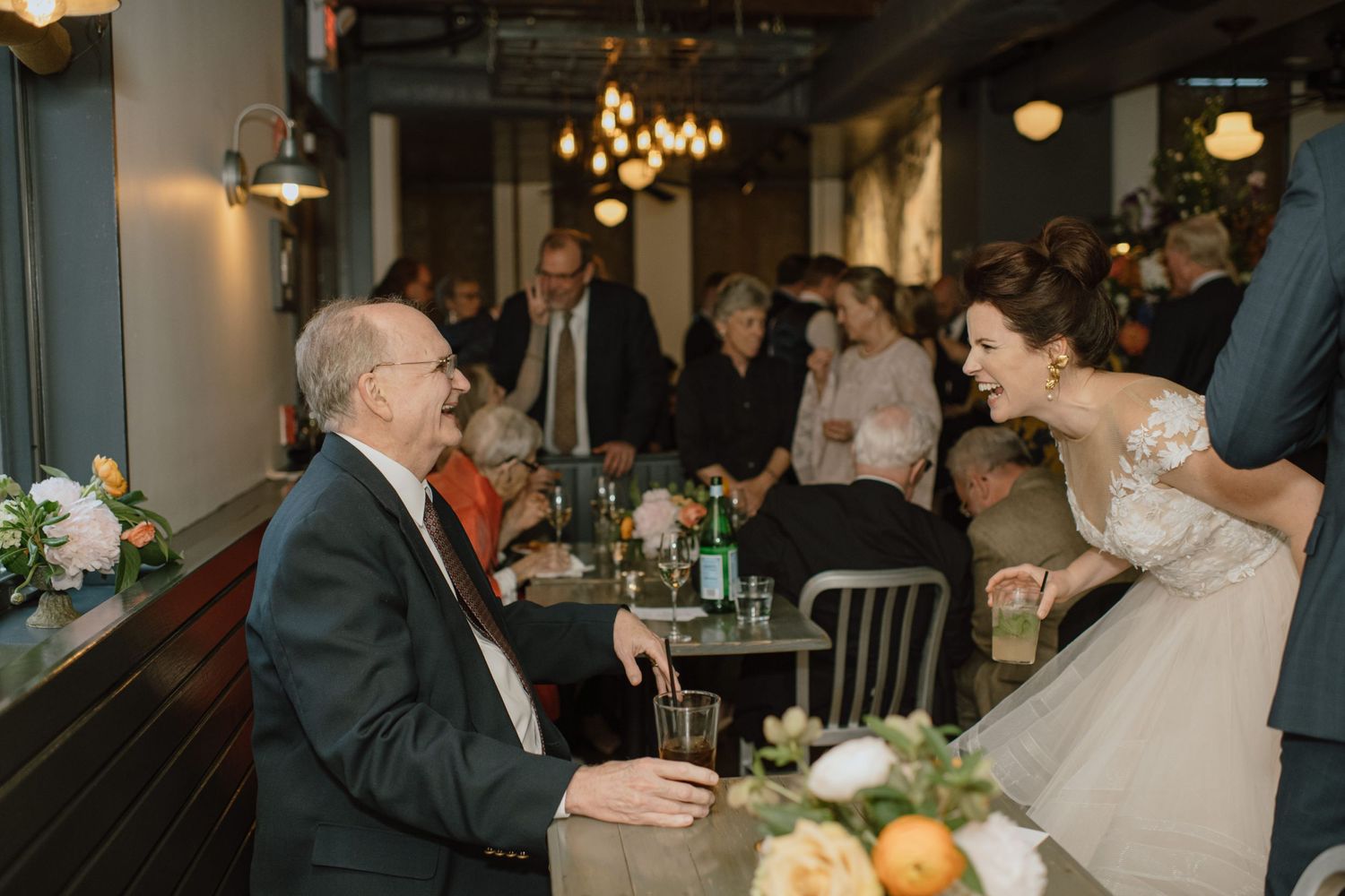 A joyful moment shared between wedding guests at an indoor reception.